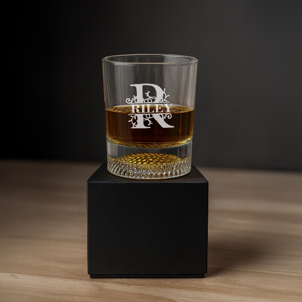 Clear glass with engraved design and liquid on a black cube against a dark background Personalized Golf Ball Whiskey Glass Set Rock Bourbon Glass Groomsmen Gift Golf Father Day Gift Golf Gifts for Men Custom Scotch Glass Chill